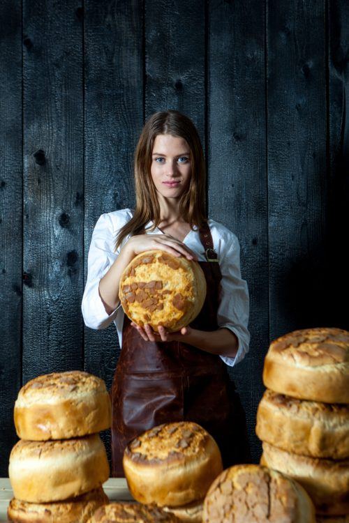 Brutăriță ținând o pâine rotundă